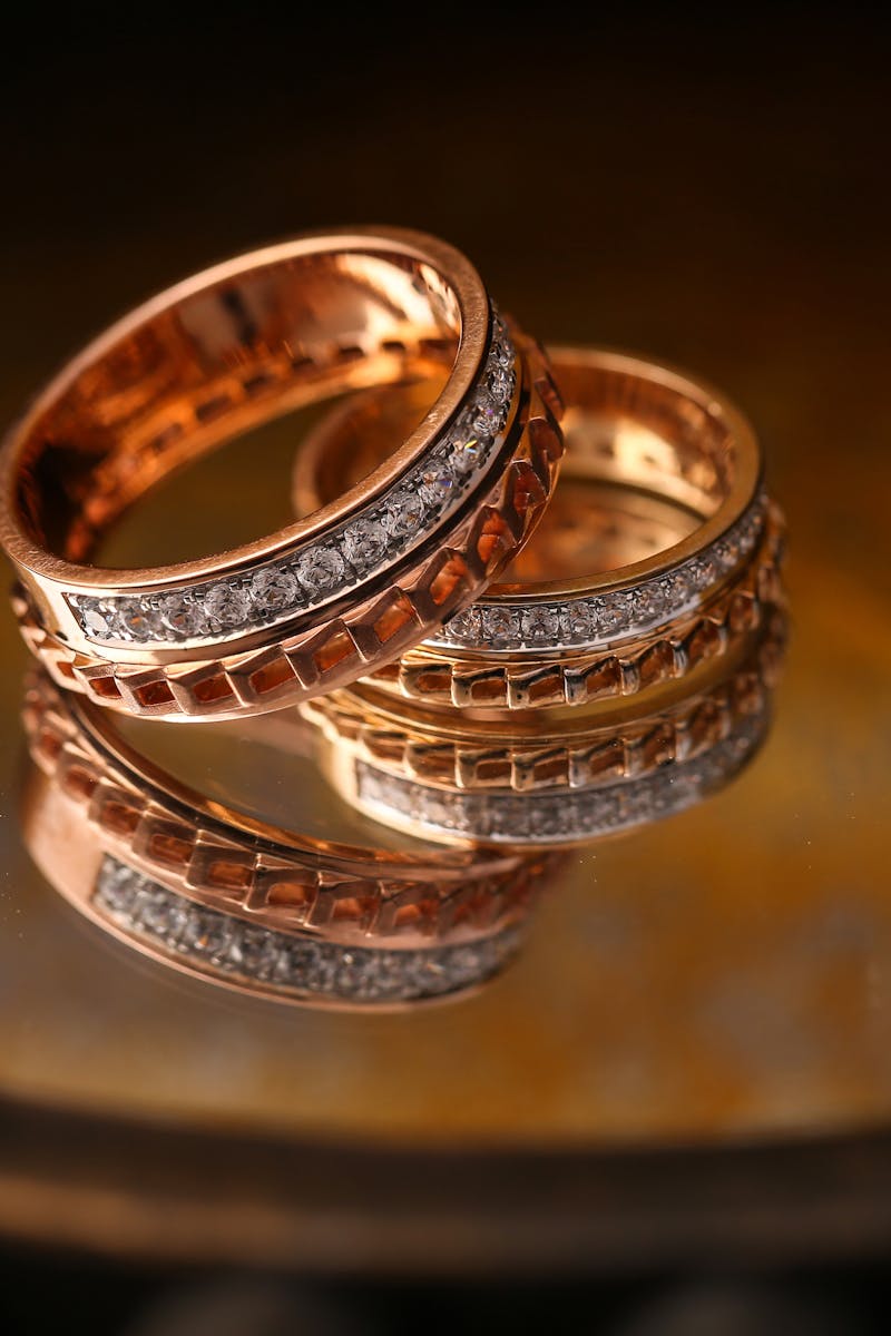 Close-up of luxury gold and diamond wedding rings reflecting light beautifully.